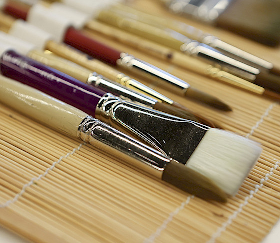 Close up photo of paintbrushes in an open brush case.